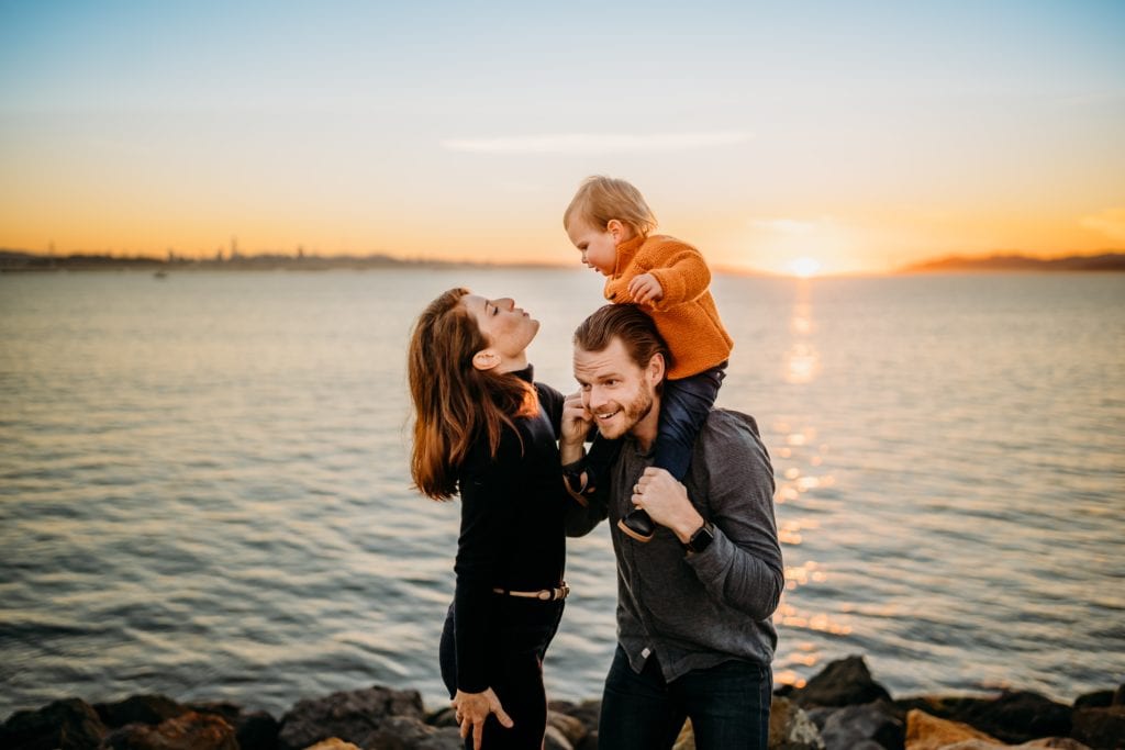 Family of 3 plays together during sunset at Cesar Chavez Park in Berkeley, CA during a family photography session with Xilo Photography.