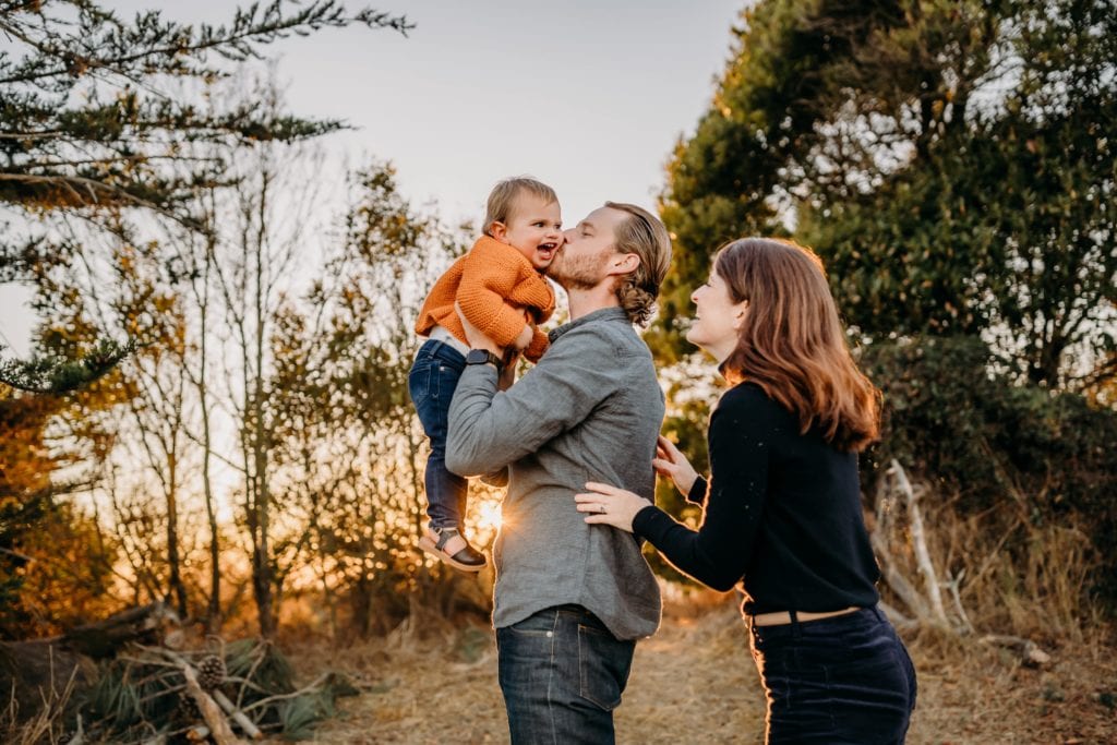 Family of 3 embracing at sunset during Cesar Chavez Park with Xilo Photography in Berkeley, CA.