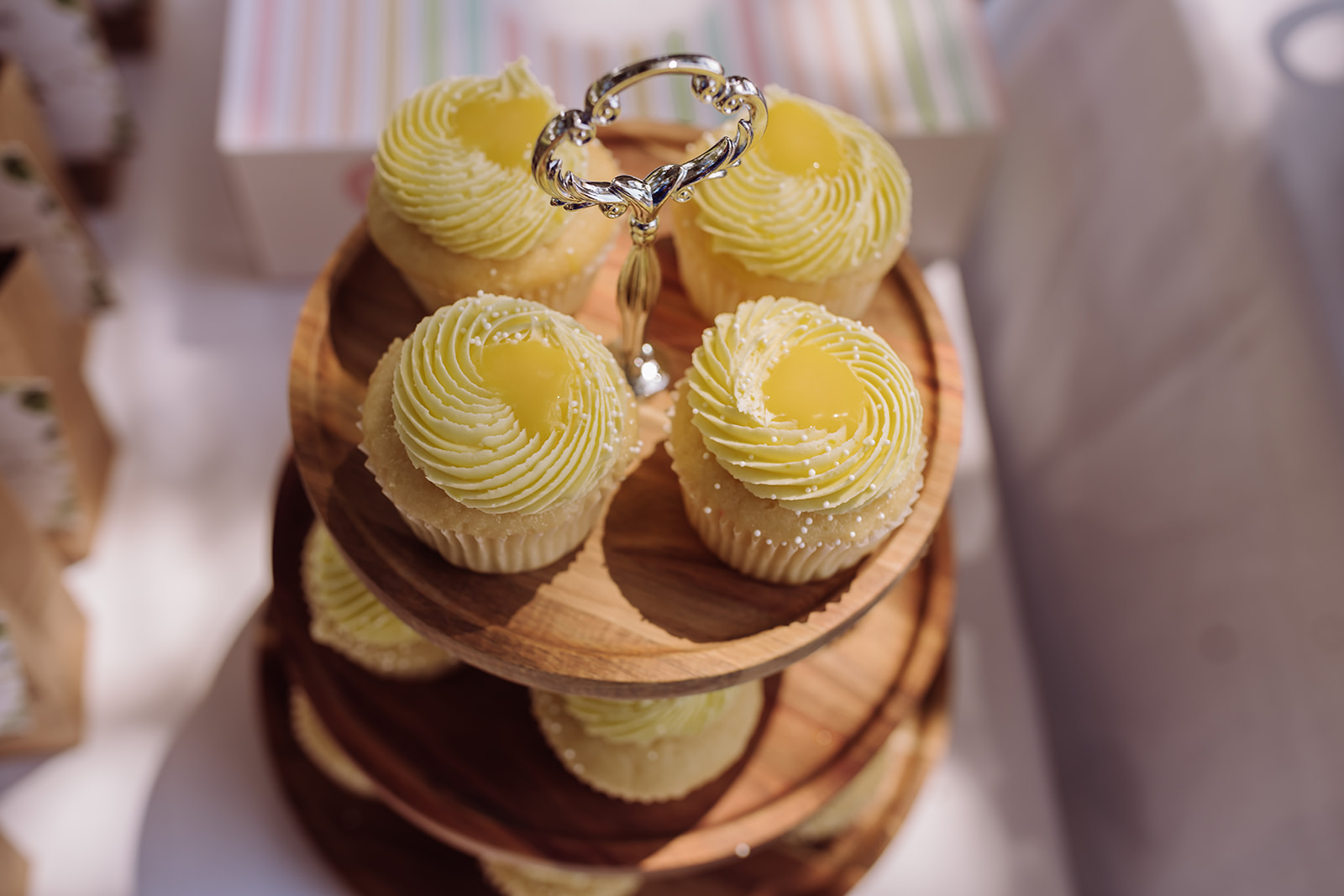 The picture shows one of the delicious lemon cupcake wedding desserts that is placed on the table for guests at a same sex gay wedding and elopement day. Such a creative and beautiful dessert idea that is presented so well on multi-tiered wooden cupcake stand. This was photographed by an inclusive and intimate wedding and elopement photographer, Xilo Photography, Kati Douglas who is based in Oakland, California in the bay area. 