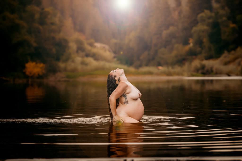 Gorgeous sun flare outdoor nude maternity photoshoot with a San Francisco Bay Area mother to be at Russian River, captured by talented and inclusive photographer, Kati Douglas of Xilo Photography based in Oakland California and photographing humans all over the San Francisco Bay Area