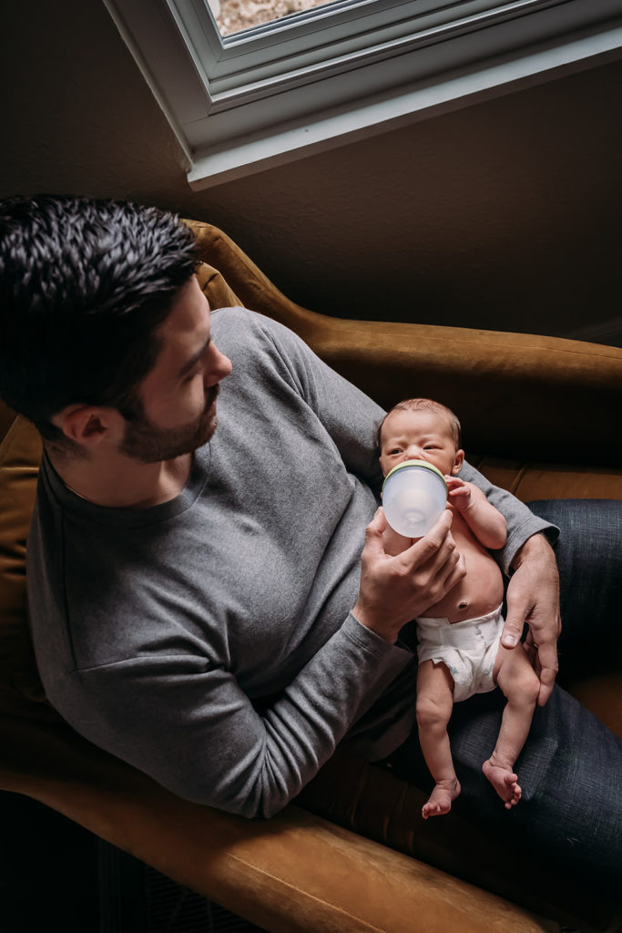 Father and newborn son bonding during their at home lifestyle and documentary newborn photography session in El Cerrito, CA by Kati Douglas, Documentary Photographer at Xilo Photography