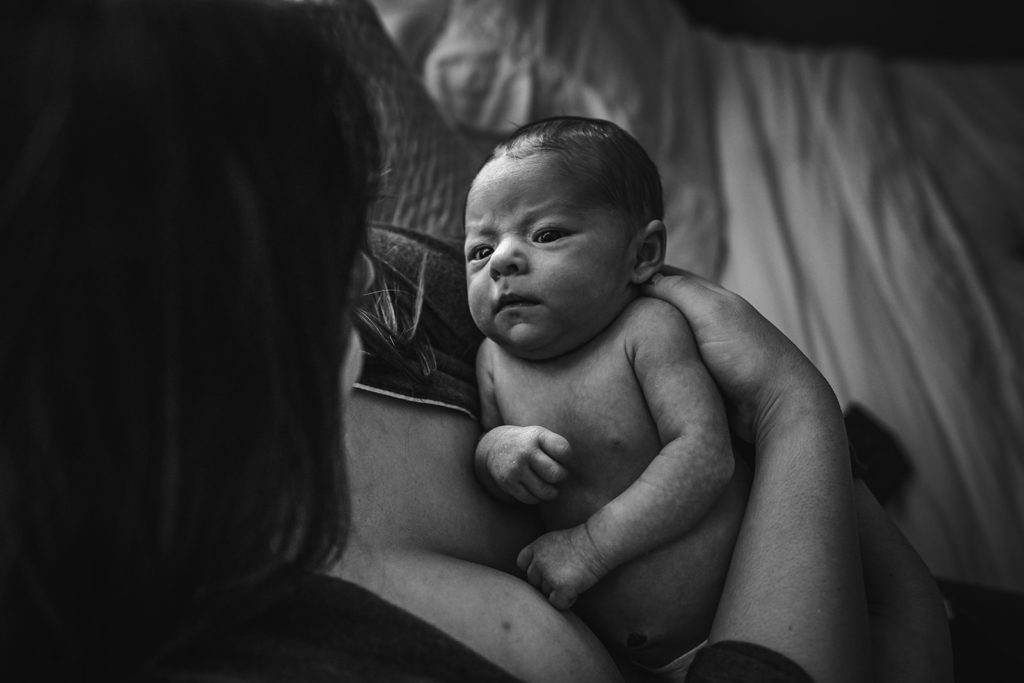 Skin to skin newborn pose with mother and son during documentary photography session in San Francisco Bay Area with Xilo Photography